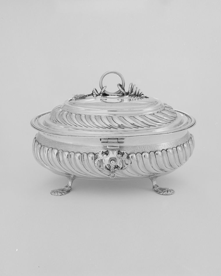 A round, silver sugar box.
